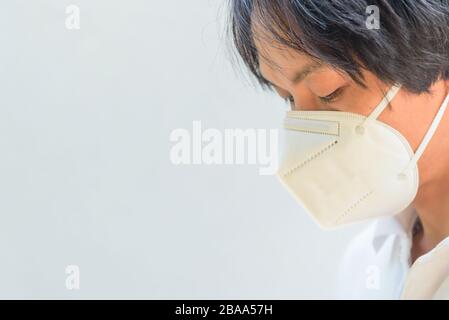 Ein asiatischer Mann trägt N95-Maske zum Schutz von PM2,5-Staub und -Krankheiten Stockfoto