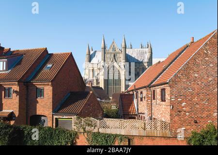 Blick auf das antike Münster durch moderne Stadthäuser an einem schönen Frühlingmorgen unter blauem Himmel in Beverley, Yorkshire, Großbritannien. Stockfoto