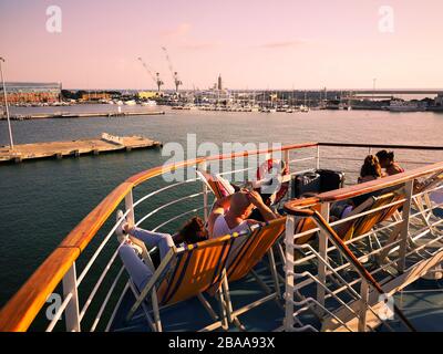 Passagiere einer Fähre auf Liegestühlen entspannen und in Urlaub fahren. Stockfoto