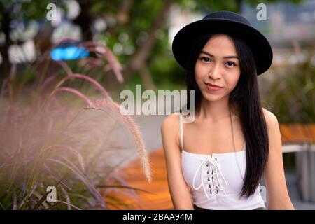Junge, schöne asiatische Touristenfrau im Dachgarten Stockfoto