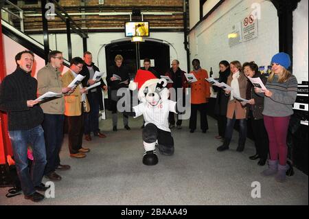 Billy the Badger dirigiert Lieder, die zu Weihnachten im Cottage vom Chor gesungen werden Stockfoto