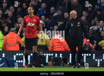 Rio Ferdinand von Manchester United (links) mit einem Angehörigen des medizinischen Personals, als er mit einem Schnitt auf der Stirn wegläuft, nachdem er von einer Münze getroffen wurde, die aus der Menge geworfen wurde Stockfoto