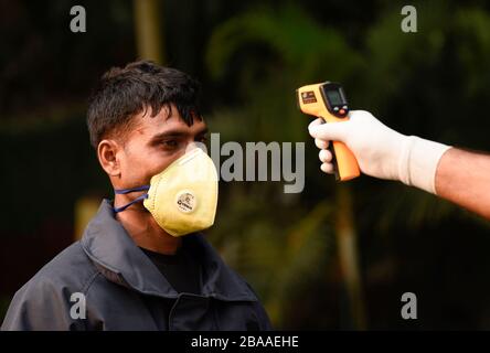 Guwahati, Assam, Indien. März 2020. Das Personal der Polizei hat eine Person vor dem Eintreten in das Gouverneurshaus zum Sprühen von Desinfektionsmitteln in Guwahati thermisch vorgeführt. Credit: David Talukdar/ZUMA Wire/Alamy Live News Stockfoto