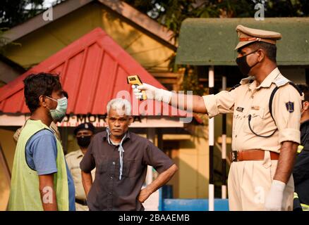 Guwahati, Assam, Indien. März 2020. Das Personal der Polizei hat eine Person vor dem Eintreten in das Gouverneurshaus zum Sprühen von Desinfektionsmitteln in Guwahati thermisch vorgeführt. Credit: David Talukdar/ZUMA Wire/Alamy Live News Stockfoto