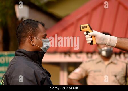 Guwahati, Assam, Indien. März 2020. Das Personal der Polizei hat eine Person vor dem Eintreten in das Gouverneurshaus zum Sprühen von Desinfektionsmitteln in Guwahati thermisch vorgeführt. Credit: David Talukdar/ZUMA Wire/Alamy Live News Stockfoto