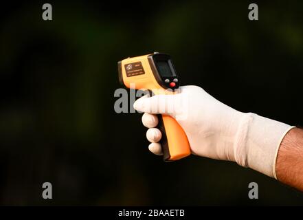 Guwahati, Assam, Indien. März 2020. Das Personal der Polizei hat eine Person vor dem Eintreten in das Gouverneurshaus zum Sprühen von Desinfektionsmitteln in Guwahati thermisch vorgeführt. Credit: David Talukdar/ZUMA Wire/Alamy Live News Stockfoto