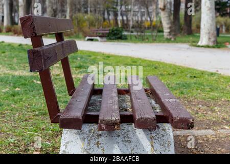 Seitenansicht der leeren Holzbank im öffentlichen Park Stockfoto