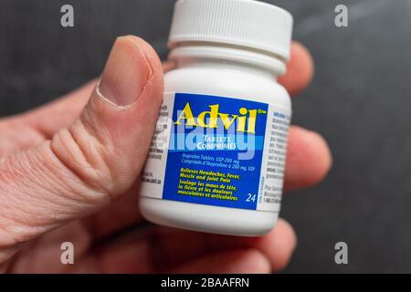 Montreal, CA 26. März 2020: Hand mit einer Flasche Advil Ibuprofen Pillen. Stockfoto