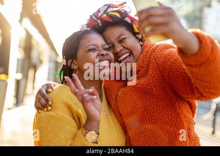 Zwei schöne afro-amerikanische Frauen in einem städtischen Stadtgebiet Stockfoto
