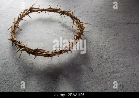 Dornenkrone auf hellem Hintergrund mit Kronenschatten. Religionskonzept. Osterhintergrund Stockfoto