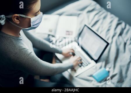 Schulmädchen studiert zu Hause per E-Learning wegen Corona Virus Covid-19 Quarantäne, Homeschooling Stockfoto