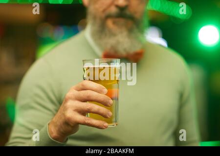 Nahaufnahme eines bärtigen Mannes, der ein Glas Bier in der Hand hält, während er in der Bar Spaß hat Stockfoto