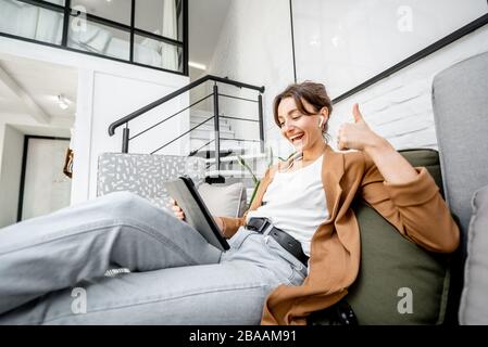 Porträt einer jungen Frau, die während der Arbeit von zu Hause aus einen Videoanruf auf einem digitalen Tablet hat. Konzept einer freiberuflichen und kreativen Arbeit online Stockfoto