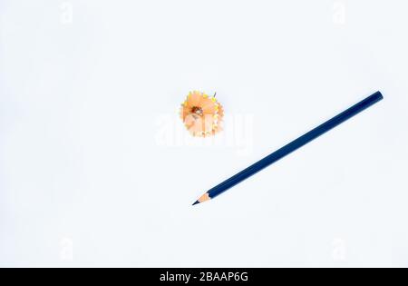 Ein dunkelblau gefärbter Bleistiftkrebse aus Holz, der neben einigen Bleistiftspänen auf weißem Hintergrund platziert ist Stockfoto