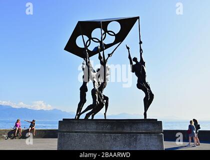 Denkmal der Menschen, die olympische Flagge auf dem Genfer See tragen, Ouchy, Lausanne, Schweiz. Stockfoto