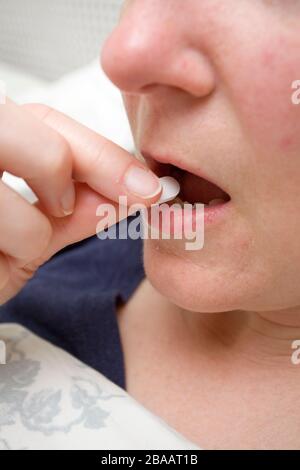 Frau, die die Schmerztablette in die Nähe nimmt Stockfoto