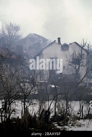 26. Januar 1994 während des Krieges in Zentralbosnien: Häuser, die noch schwelen, nachdem das bosnisch-muslimische Dorf hier zwei Tage zuvor von HVO-Truppen eingenommen worden war. Stockfoto