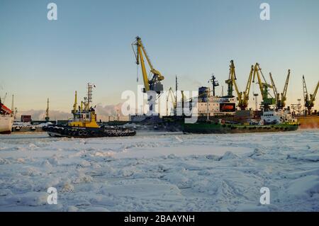 St. Petersburg, Russland - 20. Februar 2011: Schiffe und Kräne im Hafen von St. Petersburg im Winter Zeit, durch Eis und Schnee Stockfoto