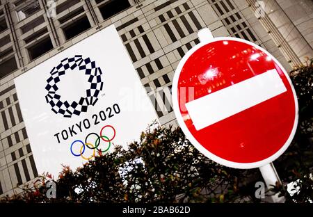 24. März 2020, Tokio, Japan: Ein Verkehrszeichen "Do no Entry" neben einem Regierungsgebäude in Tokio mit einem riesigen olympischen Banner von Tokio 2020, am Dienstag. Das Internationale Olympische Komitee für Empfehlungen der WHO (Weltgesundheitsorganisation), des IOC-Präsidenten Bach und des Premierministers von Japan S. Abe hat heute die Sommerspiele 2020 in Tokio der XXXII Olympiade verschoben. Die Umscheduled auf ein Datum über 2020 hinaus, aber bis Sommer 2021, um die Gesundheit der Athleten, alle an den Olympischen Spielen und der internationalen Gemeinschaft beteiligt. (Bild: © Ramiro Agustin Vargas Tabares/Z Stockfoto