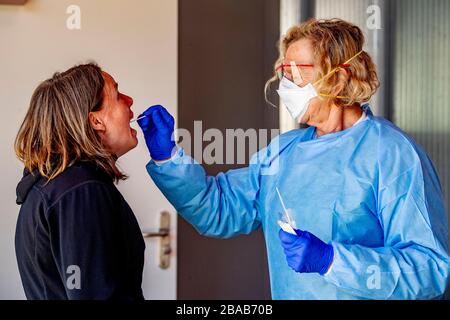 Eine Krankenschwester, die einen COVID-19 Coronavirus Test einer Person auf einer Fahrt durch das Testzentrum gegeben hat. EINE Fahrt durch das COVID-19 Coronavirus Testzentrum wurde in Amsterdam AMC Krankenhaus eingerichtet, um Testdienste für die Öffentlichkeit bereitzustellen. Die Tests werden durchgeführt, indem eine Probe mit Wattestäbchen in der Nase entnommen wird. Die getesteten Personen können den Ergebnisgewinn 15 Minuten erzielen. Stockfoto