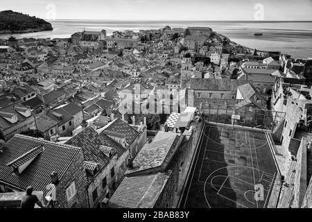 Blick auf die Altstadt von Dubrovnik, Kroatien mit allen Lehmziegeldächern sowie einem Basketballplatz mit dem Mittelmeer im Hintergrund. Stockfoto