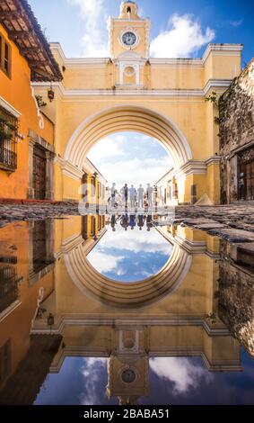 Touristen stehen unter dem Santa Catalina Bogen in Antigua, Guatemala Stockfoto