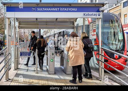 Istanbul, Türkei - 11. Februar 2020: Passagiere fahren durch Fahrkartendrehkreuze zum Straßenbahnbahnhof. Stockfoto