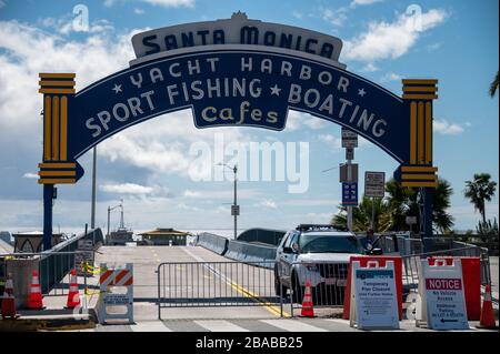 Ein Polizeifahrzeug bemannt den Eingang zu einem geschlossenen Santa Monica Pier, einer der beliebtesten Touristenattraktionen im Süden Kaliforniens am 25. März 2020 Stockfoto