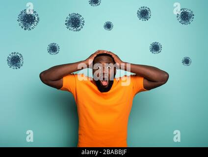 Ängstlicher Ausdruck eines Jungen, der Angst hat, das Coronavirus zu fangen. Hintergrund Zyan Stockfoto