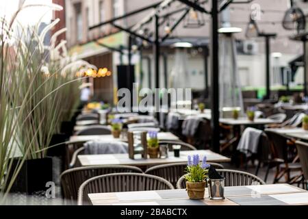 Holztisch mit Servietten und condiments im völlig leeren rustikalen Restaurant mit jetzt Menschen und Kunden während der koviden 19 Corona-Virus-Pandemie shu Stockfoto