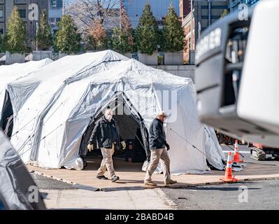 New York, NY - 26. März 2020: Arbeiter des Büros der medizinischen Prüferei beaufsichtigen den Bau von Zelten für Überlaufkapazitäten für Stadtmorgues auf der Manhattan-East-Side in der Nähe des Bellevue-Krankenhauses Stockfoto