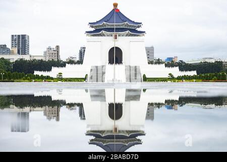 Atemberaubender Blick auf die Nationale Chiang Kai-Schek-Gedenkhalle in der Ferne mit ihrer Reflexion in einer Pfütze im Vordergrund. Stockfoto