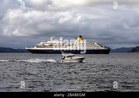Kleines Vergnügen Handwerk Frieden, am Byfjorden außerhalb des Hafen von Bergen, Norwegen. Vorbeifahrender Kreuzfahrtschiff Saga Sapphire Stockfoto