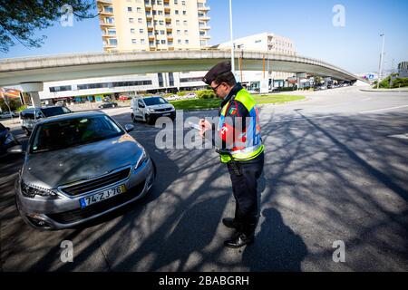 Ein Polizeibeamter nimmt das Kennzeichen und den Führerschein zur Kenntnis.in der Stadt Porto überwachen bereits mehrere Polizeibeamte, die auf der Straße nach den neuen, von der Regierung festgelegten Regeln ausfahren. Nach der Erklärung eines Ausnahmezustands aufgrund der drohenden Coronavirus-Pandemie. Stockfoto