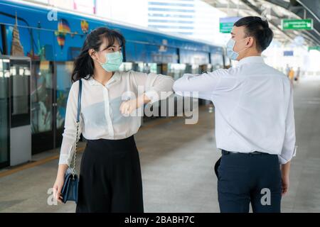 Ellenbogenschlag ist eine neue neue Begrüßung, um die Ausbreitung von Coronavirus zu vermeiden. Zwei asiatische Wirtschaftsfreunde treffen sich in der U-Bahn-Station. Statt mit einer Umarmung zu grüßen Stockfoto