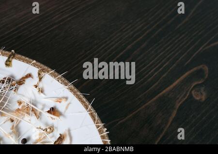 Fischknochen auf einem einzigen weißen Teller. Holztisch Hintergrund. Winkelaufnahme mit Kopierbereich Stockfoto