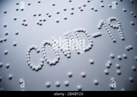 Textphrase Covid-19 Zeichenkonzept aus weißen Pillen auf weißem Hintergrund Stockfoto