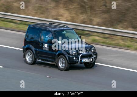 BJ52OKL 2002 Suzuki Jimny Special Black Car Petrol Fahren auf der Autobahn M6 in der Nähe von Preston in Lancashire, Großbritannien Stockfoto