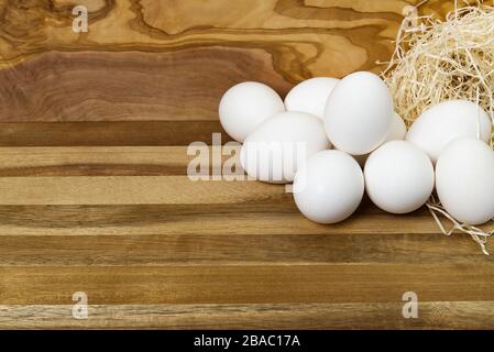 Weiße Hühnereier und zerbrochene Eier auf Holzbrett oder Tisch. Stockfoto