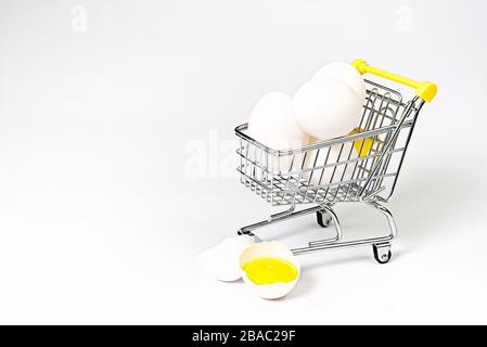 Huhn weiße Eier in einem Einkaufswagen. Zerbrochenes Hühnchen weißes Ei. Isoliert auf Weiß Stockfoto