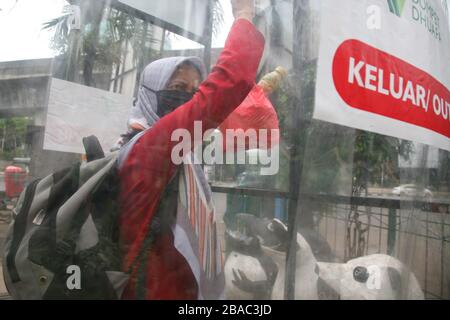 Jakarta, Indonesien. März 2020. Einwohner, die an öffentlichen Orten aktiv sein werden, nutzen die Desinfektionskammer in Blok M, Süd-Jakarta, Indonesien. In dieser Sterilisationskammer wird der gesamte Körper der Person mit Desinfektionsflüssigkeit besprüht. Diese Desinfektionsflüssigkeit dient dazu, den Corona-Virus, der an der Kleidung oder dem Körper der Person haftet, zu töten, um die Ausbreitung des Corona-Virus (COVID-19) im öffentlichen Raum zu antizipieren. (Foto von Kuncoro Widyo Ruumpoko/Pacific Press) Credit: Pacific Press Agency/Alamy Live News Stockfoto