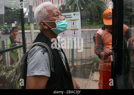 Jakarta, Indonesien. März 2020. Einwohner, die an öffentlichen Orten aktiv sein werden, nutzen die Desinfektionskammer in Blok M, Süd-Jakarta, Indonesien. In dieser Sterilisationskammer wird der gesamte Körper der Person mit Desinfektionsflüssigkeit besprüht. Diese Desinfektionsflüssigkeit dient dazu, den Corona-Virus, der an der Kleidung oder dem Körper der Person haftet, zu töten, um die Ausbreitung des Corona-Virus (COVID-19) im öffentlichen Raum zu antizipieren. (Foto von Kuncoro Widyo Ruumpoko/Pacific Press) Credit: Pacific Press Agency/Alamy Live News Stockfoto