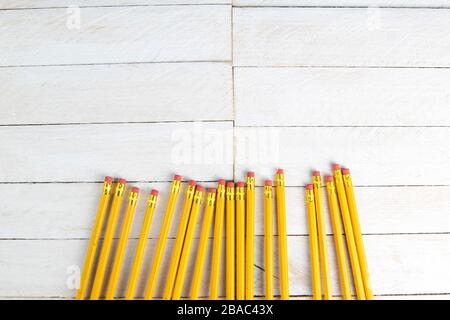 Ein Satz orangefarbener Bleistifte auf einem weißen Holztisch. Drucken von Verbrauchsmaterialien Stockfoto
