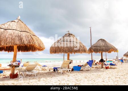 Unerkennbare Strandgänger strömen während des beliebten Winterausflugens zur karibischen Küste zu den tropischen Stränden der Riviera Maya in der Nähe von Cancun, Mexiko. Stockfoto