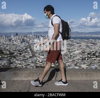 San Francisco, Vereinigte Staaten. März 2020. Ein maskierter Mann läuft am Donnerstag, 26. März 2020, auf Twin Peaks in San Francisco. Kalifornien ist unter einem Befehl für einen Aufenthalt zu Hause, mit Ausnahme wesentlicher Bedürfnisse wie Lebensmittelgeschäfte wegen der Coronavirus Pandemie. Foto von Terry Schmitt/UPI Credit: UPI/Alamy Live News Stockfoto