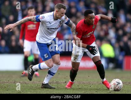 Tranmere Rovers' Peter Clarke (links) und Anthony Martial von Manchester United um den Ball kämpfen Stockfoto