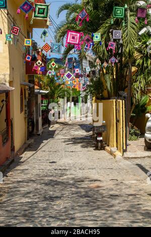 Der bunte Ojo de dios zog über eine leere Kopfsteinpflasterstraße in der Stadt Sayulita, Mexiko, Nayarit. Stockfoto