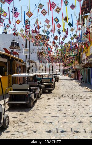 Der bunte Ojo de dios streunte über eine Kopfsteinpflasterstraße in der Stadt Sayulita, Mexiko, Nayarit. Stockfoto