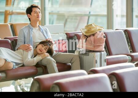 Das junge Paar sitzt in der Flughafenlounge Stockfoto