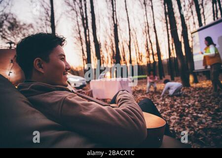 Am Abend spielt die glückliche Familie beim Campen im Freien Stockfoto